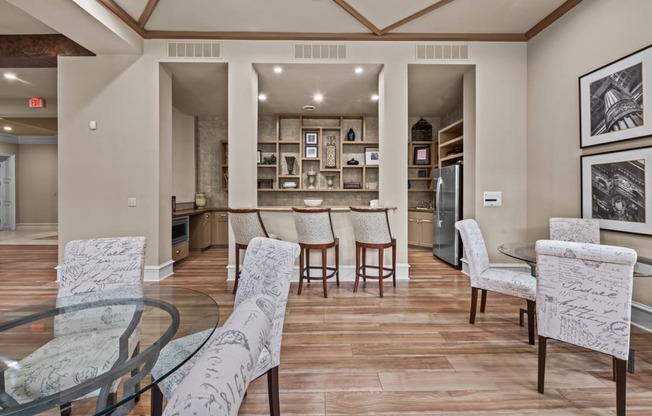 club house  with a glass table and chairs and a kitchen in the background