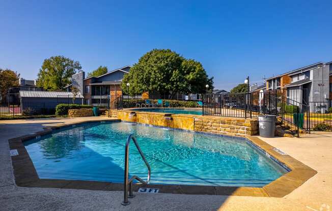 a swimming pool with a reflection of a building and a fountain