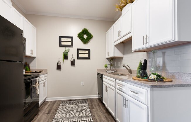 Spacious kitchen with white cabinetry and black energy efficient appliances at The Summit on 401 in Fayetteville, NC