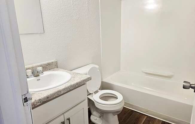 A white toilet sits next to a sink in a small bathroom.