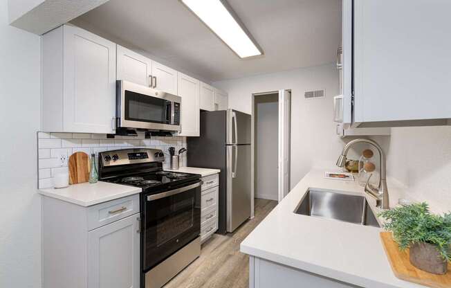 A kitchen with white cabinets and a black stove top oven.