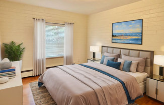 Inviting bedroom with elegant decor, featuring a cozy king-sized bed, modern artwork, and abundant natural light.
