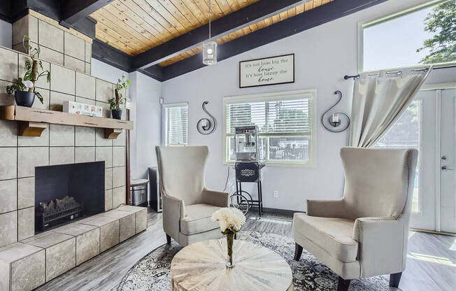 a living room with a fireplace and two chairs