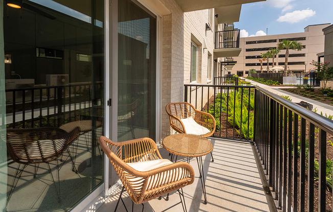 a balcony with wicker chairs and a table on a balcony