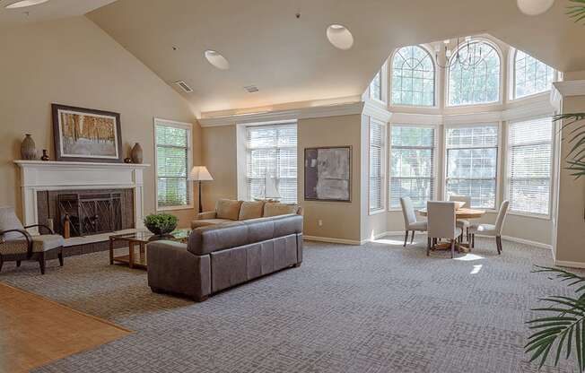 a living room with a couch and a fireplace and a table and chairs