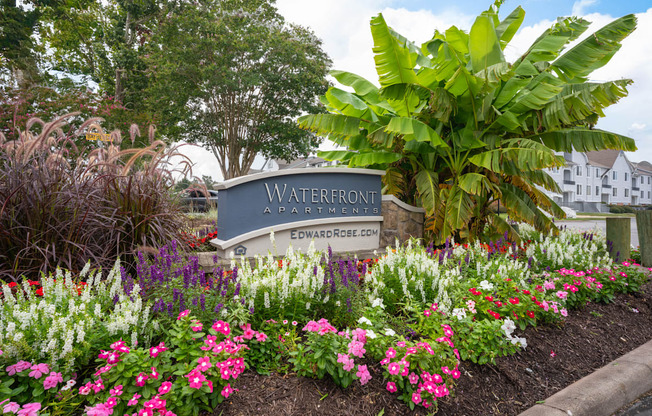 A sign that says Waterfront in front of some flowers.