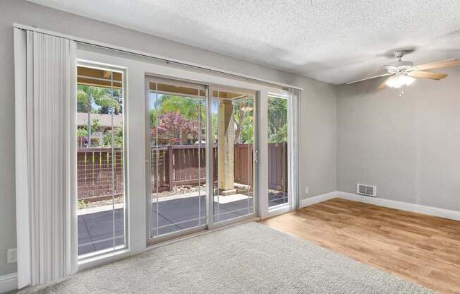 an empty living room with sliding glass doors to a patio at Summerwood Apartments, Santa Clara, 95050