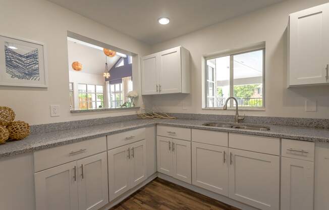 a large kitchen with white cabinets and granite counter tops