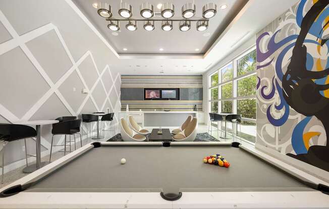 a billiards room with a pool table and chairs