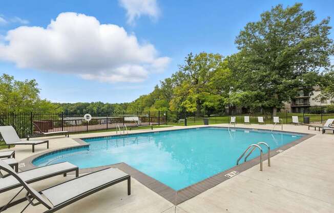A large outdoor swimming pool surrounded by lounge chairs.