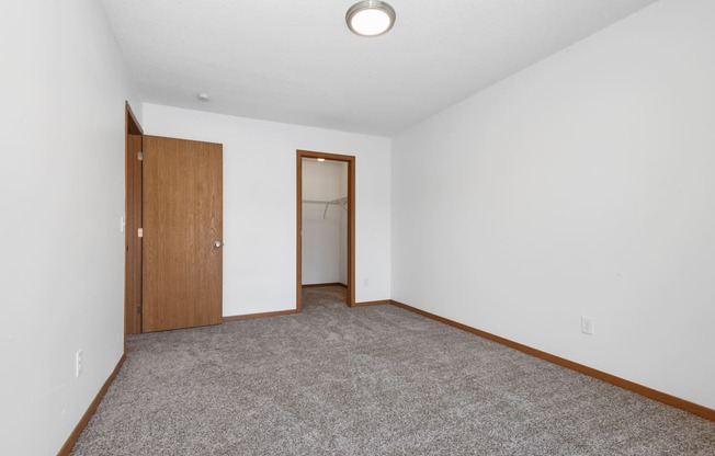 St. Louis Park, MN Courtyard Apartments. A  bedroom with a carpeted floor and a door to a closet