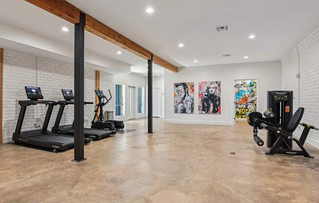 A spacious gym with treadmills, exercise bikes, and a weight bench.
