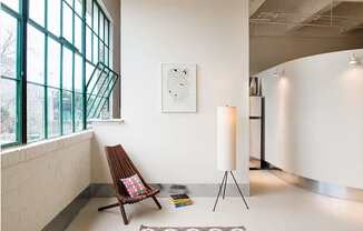 A room with a chair and a painting on the wall.