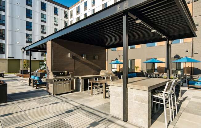 Covered courtyard with picnic area seating, bbq grills and lounging area. at POLARIS AT SEATAC, SEATAC, WA
