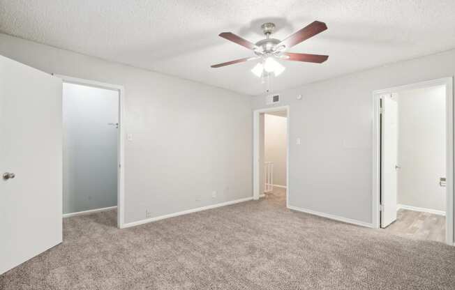 a bedroom with a ceiling fan and white walls