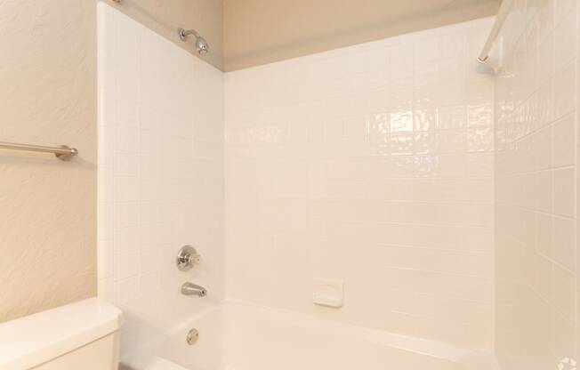 a white bathroom with a shower and a toilet