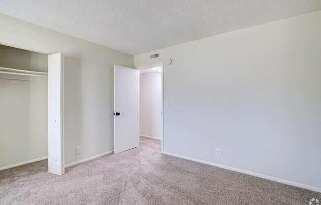 an empty living room with white walls and carpet