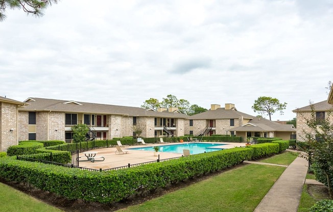 the view of a swimming pool with apartments in the background