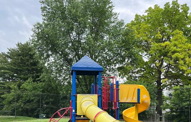 A playground with a blue and yellow slide.