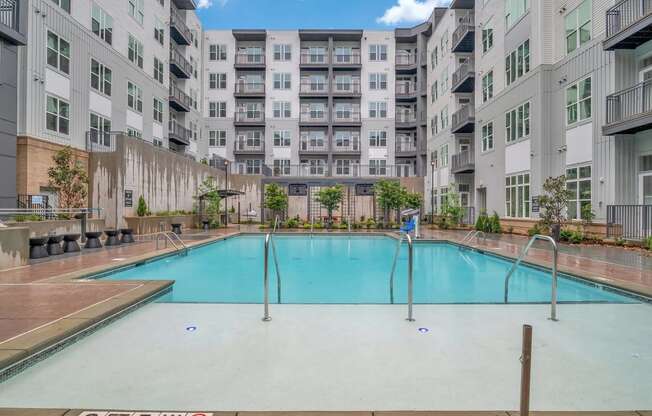 a large swimming pool in front of an apartment building