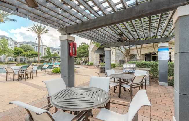 A patio with a table and chairs under a roof.