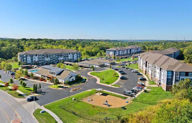 A large apartment complex with a parking lot in front.