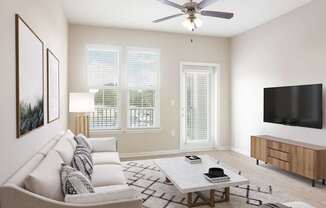 A living room with a grey couch, a coffee table, a flat screen TV, and a ceiling fan.