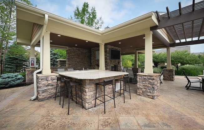 a covered patio with an outdoor kitchen and bar at Sovereign at Overland Park, Overland Park Kansas  