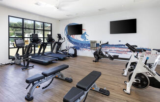 a gym with cardio equipment and a wall mural of the beach at La Jolla Blue, San Diego