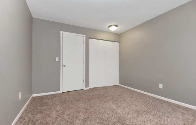 an empty room with carpet and two closet doors. Roseville, MN Rosedale Estates