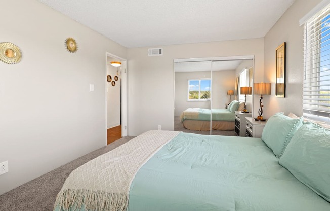 a bedroom with a large bed and a large mirror