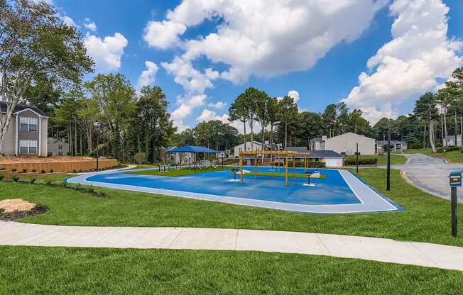 A blue swimming pool surrounded by a grassy area and trees.