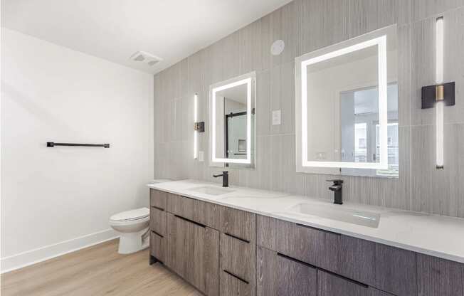 A bathroom with a toilet, sink, and mirror.