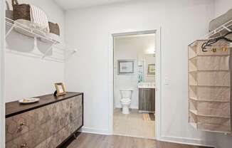 A bathroom with a toilet and a cabinet with a picture frame on top.