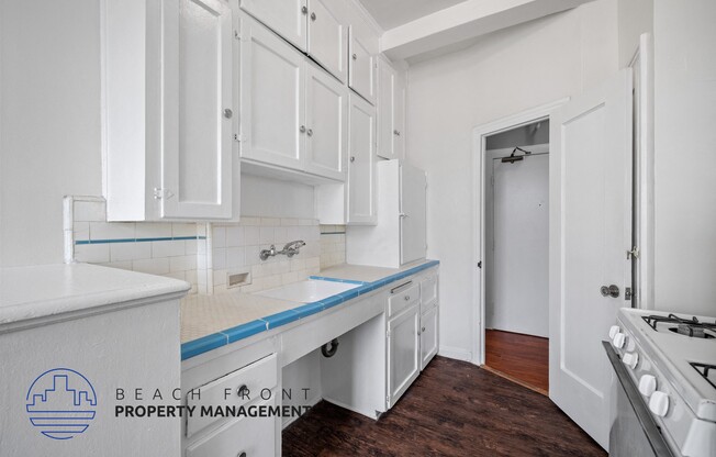 a white kitchen with white cabinets and a blue counter top