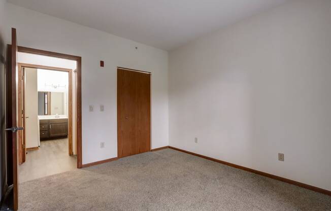 a living room with carpet and a door to a bathroom