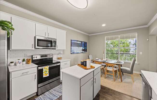 A kitchen with white cabinets and a black stove top oven.