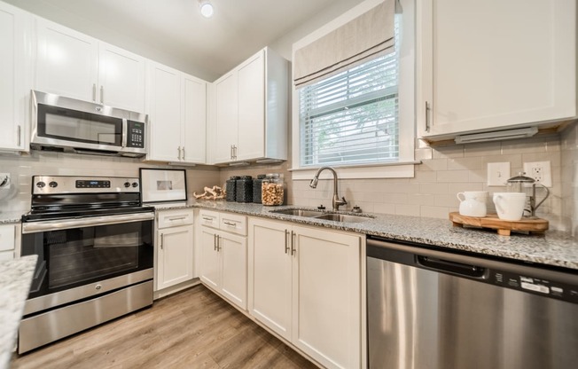 an updated kitchen with stainless steel appliances and granite counter tops