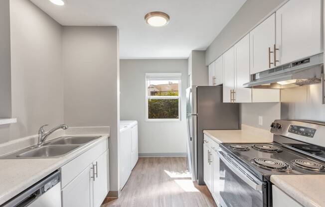 a kitchen with white cabinets and stainless steel appliances