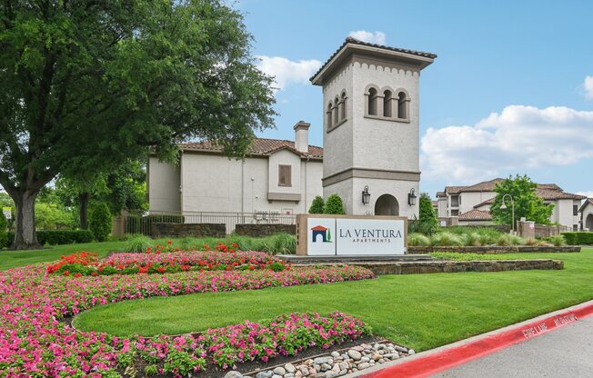 A white building with a tower and a sign that says