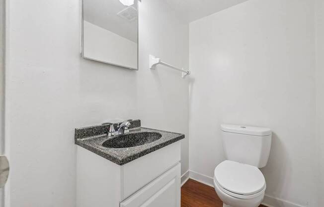 A white toilet sits next to a sink in a small bathroom.
