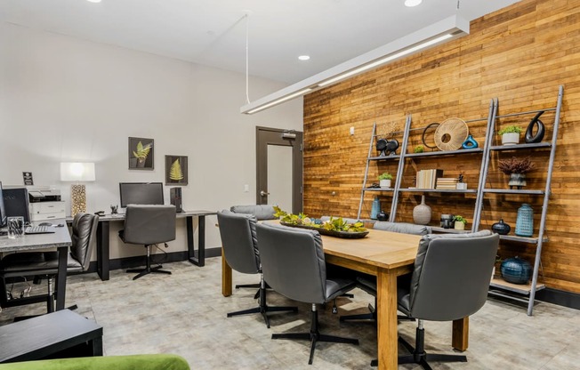 a dining room with a wooden table and chairs and a desk with a computer