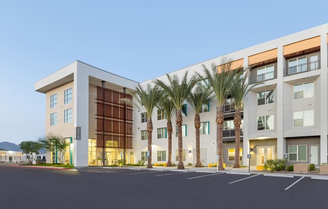 A modern building with palm trees in front.