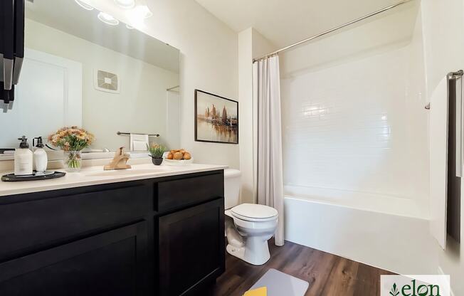 A bathroom with a toilet, sink, and mirror.