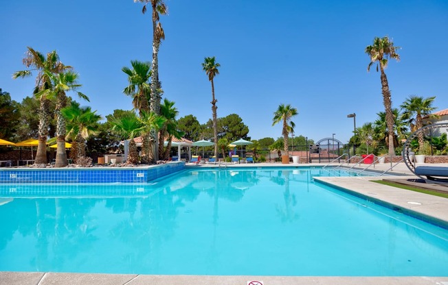 a large pool with palm trees next to it at the resort