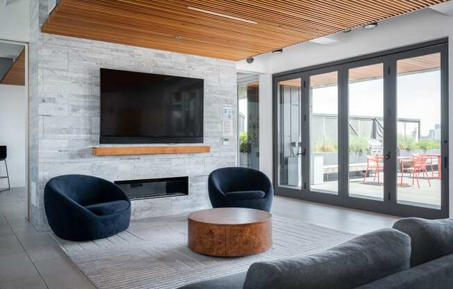 this living room has a large stone fireplace with a wooden mantle and a large flat screen tv