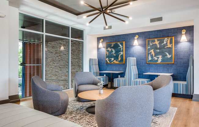 a living room with blue chairs and a blue accent wall