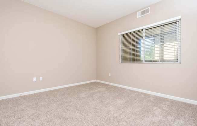 a bedroom with a window and carpet