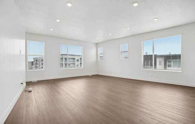 A large empty room with wooden floors and white walls.