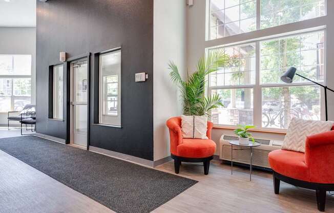 A room with a black wall and a red chair.